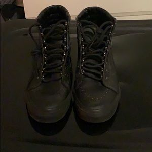 Black leather high top Vans.
